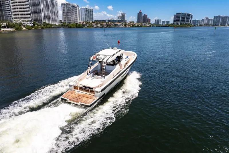 Slide: The Image of 2021 Bluegame BG 42 yacht cruising near city skyline on a sunny day. - 11