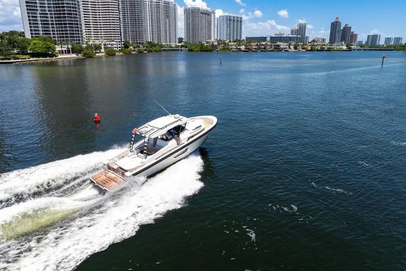 Slide: The Image of 2021 Bluegame BG 42 yacht cruising near city skyline on a sunny day. - 12