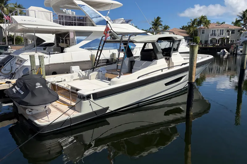 Slide: The Image of 2021 Bluegame BG 42 yacht docked in a marina, surrounded by luxury boats. - 2