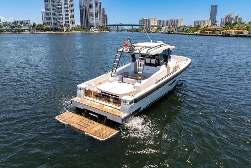 Slide: The Image of 2021 Bluegame BG 42 yacht cruising on a sunny day near city skyline. - 9
