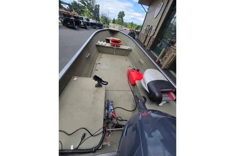 Slide: The Image of 2005 Crestliner Sportsman 16 boat interior with seating and equipment, parked outdoors. - 6
