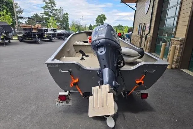 Slide: The Image of 2005 Crestliner Sportsman 16 boat with outboard motor, parked outdoors. - 7