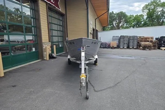 Slide: The Image of 2005 Crestliner Sportsman 16 boat on trailer outside a building. - 8