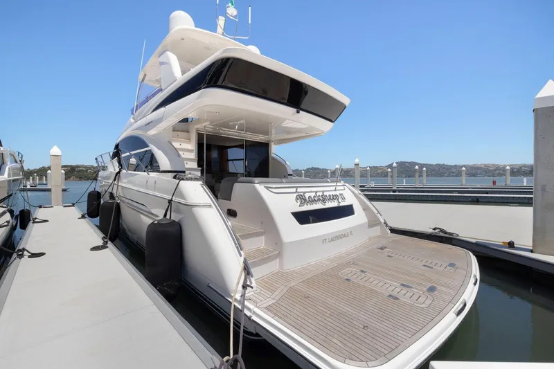 Slide: The Image of 2015 Princess 60 Flybridge Motor Yacht docked at marina, showcasing elegant design and spacious deck. - 5