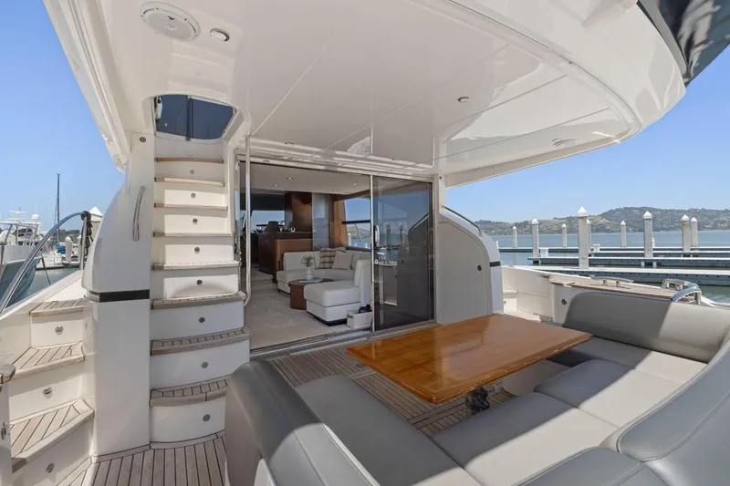 Slide: The Image of Luxurious 2015 Princess 60 Flybridge Motor Yacht with elegant outdoor seating and scenic marina view. - 7