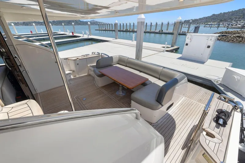 Slide: The Image of Luxurious 2015 Princess 60 Flybridge Motor Yacht with elegant outdoor seating and scenic marina view. - 9