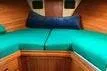 Slide: The Image of Interior cabin of 1988 Grand Banks 46 Classic with green cushions and wooden paneling. - 12