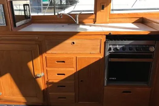 Slide: The Image of 1988 Grand Banks 46 Classic yacht kitchen with wooden cabinetry and modern appliances. - 14