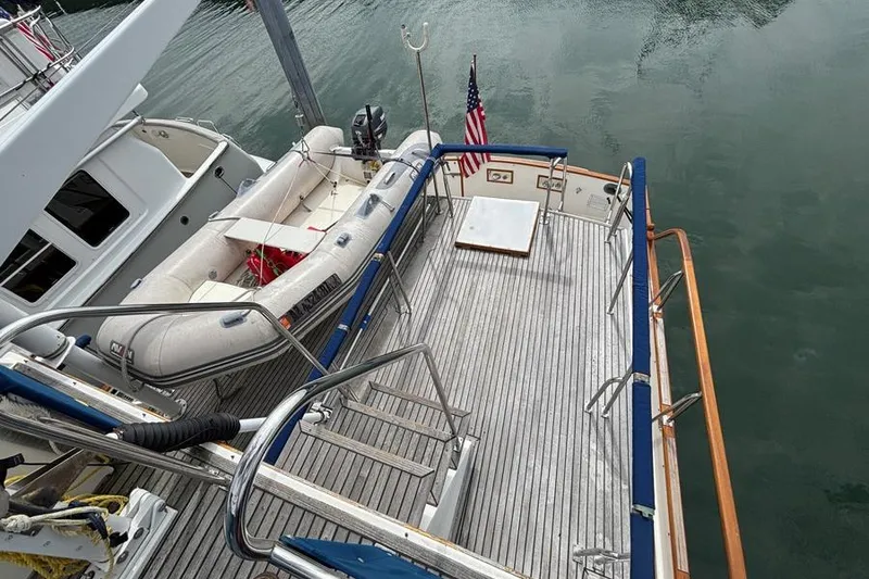 Slide: The Image of 1988 Grand Banks 46 Classic yacht deck with dinghy and American flag. - 19