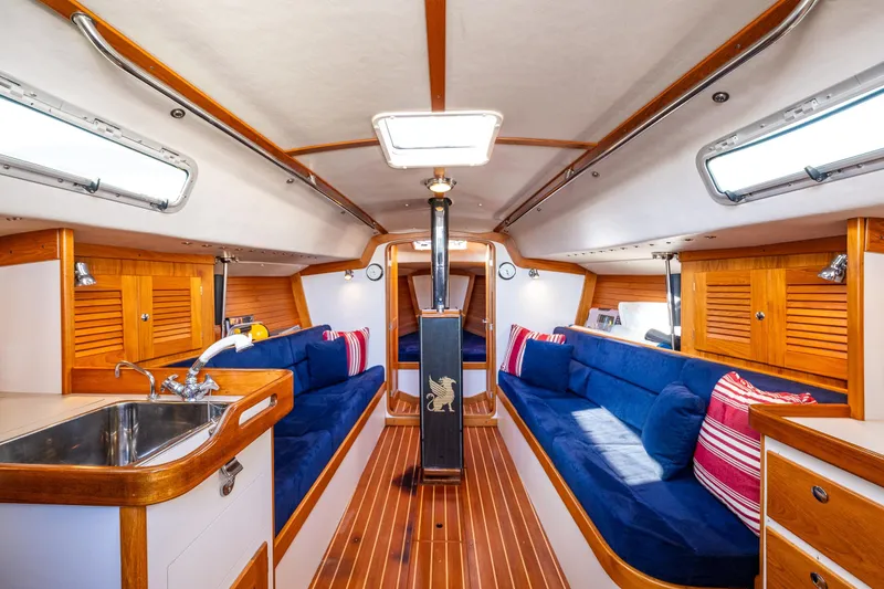 Slide: The Image of Interior of 2007 J Boats J/124 sailboat with wooden finish and blue seating. - 24