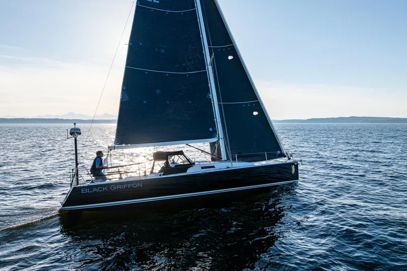 Slide: The Image of 2007 J Boats J/124 sailboat "Black Griffon" sailing on open water at sunset. - 6