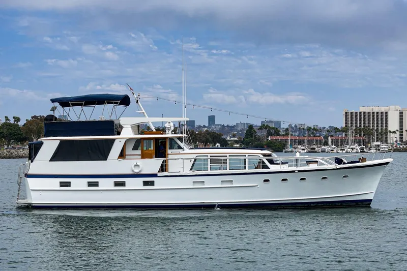 Slide: The Image of 1969 Burger Flush Deck yacht on calm water with cityscape background. - 10