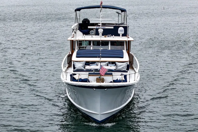 Slide: The Image of Classic 1969 Burger Flush Deck yacht cruising on calm waters, featuring elegant design and American flag. - 13