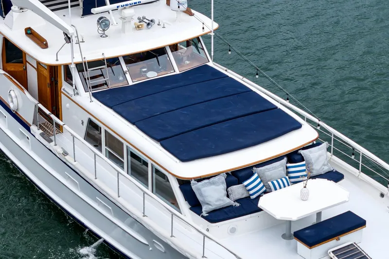 Slide: The Image of Vintage 1969 Burger Flush Deck yacht with blue cushions and striped pillows on deck. - 17