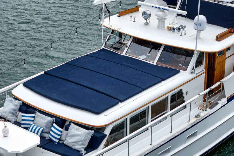 Slide: The Image of Vintage 1969 Burger Flush Deck yacht with blue cushions and striped pillows on deck. - 18