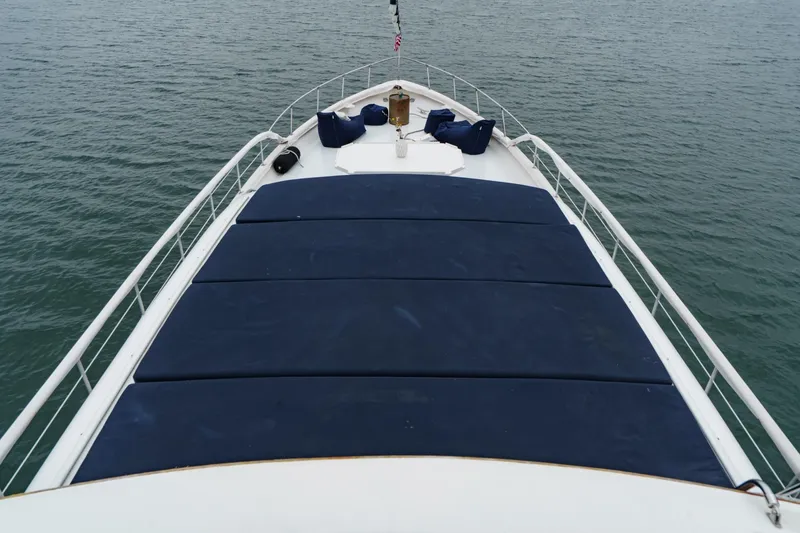 Slide: The Image of 1969 Burger Flush Deck yacht with blue cushions on deck, overlooking calm waters. - 19