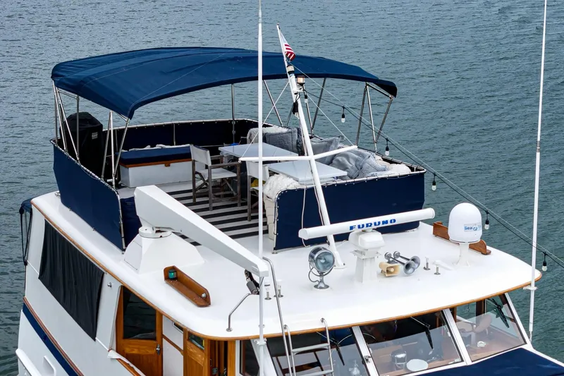 Slide: The Image of Vintage 1969 Burger Flush Deck yacht with spacious upper deck and canopy on water. - 20