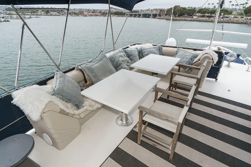 Slide: The Image of Luxurious 1969 Burger Flush Deck yacht with elegant outdoor seating and scenic waterfront view. - 22