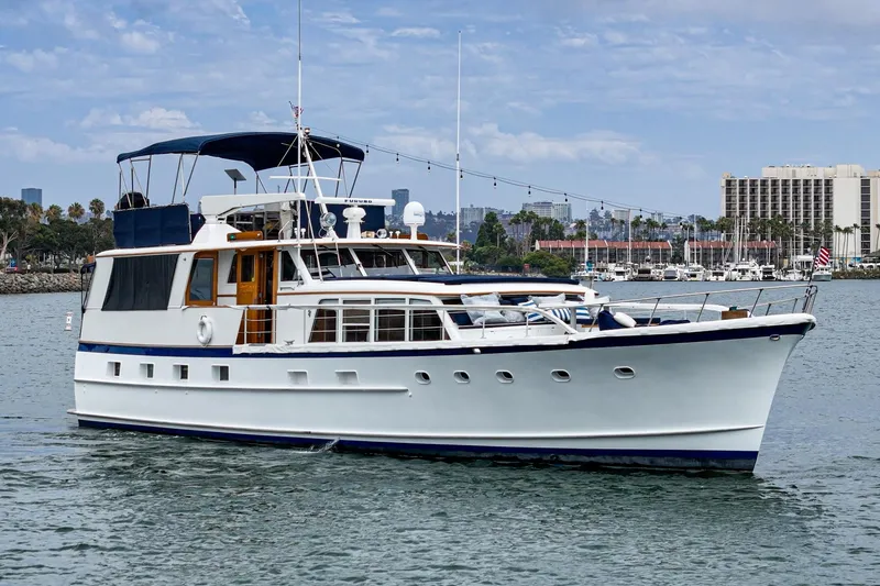 Slide: The Image of Classic 1969 Burger Flush Deck yacht cruising in a scenic harbor setting. - 3