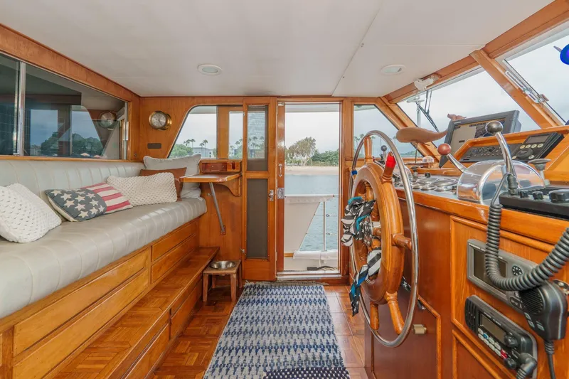Slide: The Image of Interior of a 1969 Burger Flush Deck yacht with wooden helm and seating area. - 41