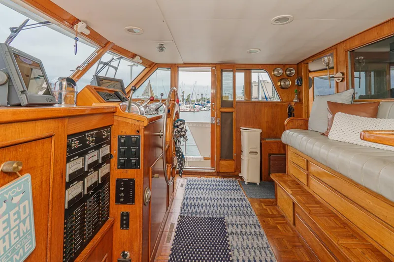 Slide: The Image of Interior of a 1969 Burger Flush Deck yacht with wooden helm and seating area. - 42