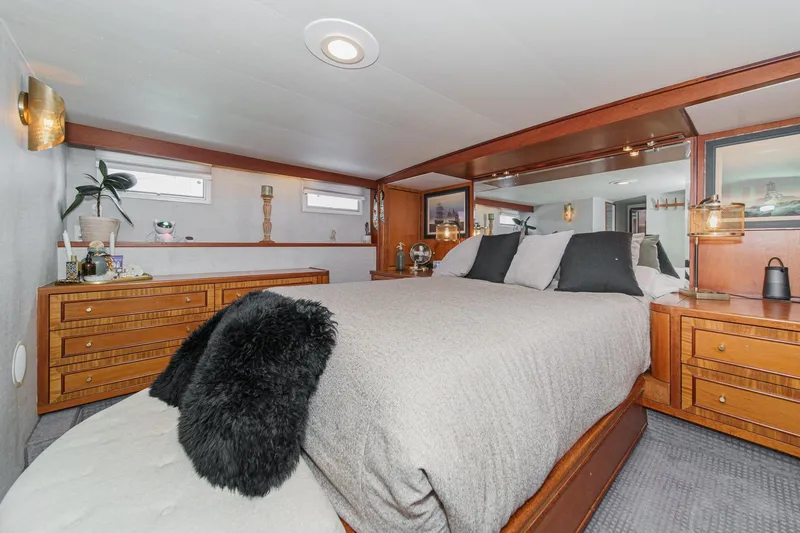 Slide: The Image of Luxurious 1969 Burger Flush Deck yacht bedroom with elegant wood furnishings and cozy bedding. - 50