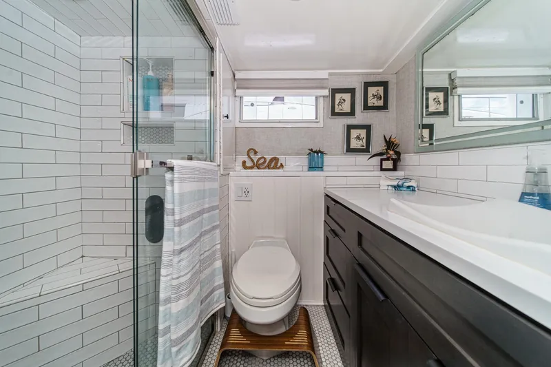 Slide: The Image of Modern bathroom with glass shower, white tiles, and dark vanity in a 1969 Burger Flush Deck. - 52