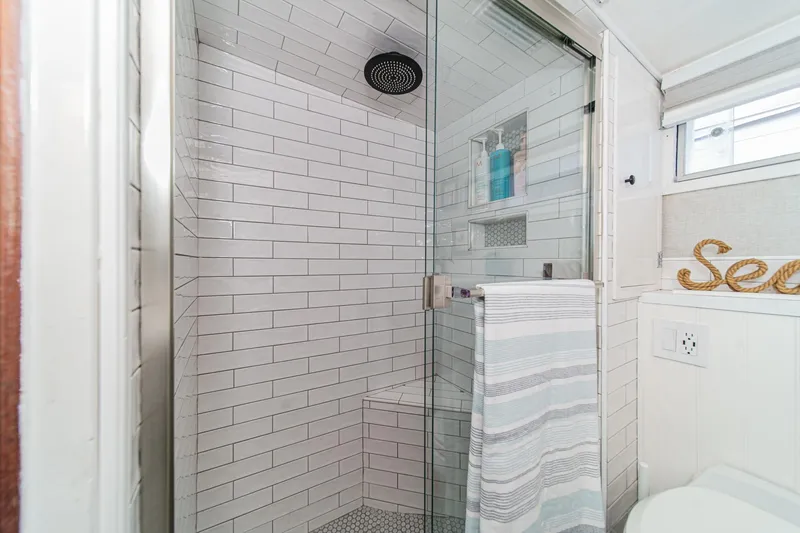 Slide: The Image of Modern shower with glass door and white subway tiles on a 1969 Burger Flush Deck yacht. - 54