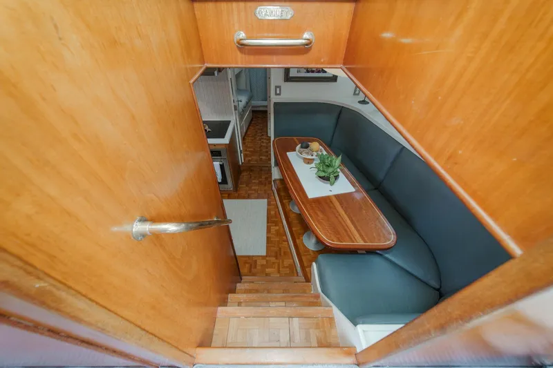 Slide: The Image of Interior view of a 1969 Burger Flush Deck yacht with wooden finishes and cozy seating area. - 57