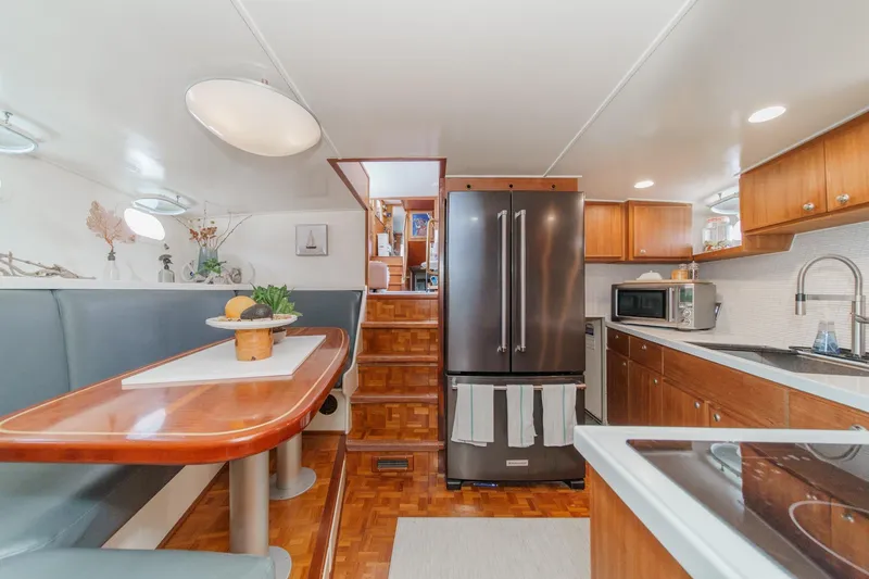 Slide: The Image of Interior of a 1969 Burger Flush Deck yacht with modern kitchen and dining area. - 58