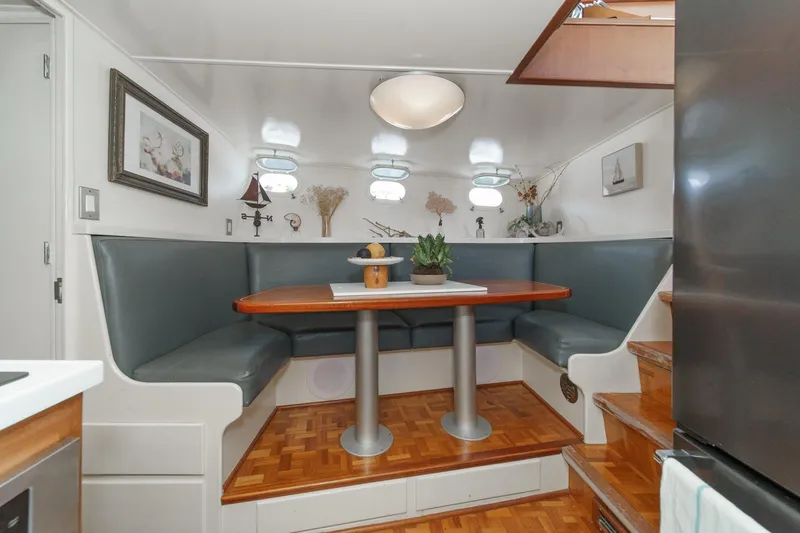 Slide: The Image of Cozy dining nook on 1969 Burger Flush Deck yacht with wood table and cushioned seating. - 59