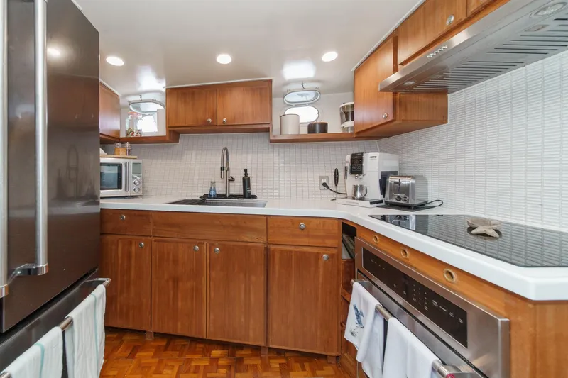 Slide: The Image of Modern kitchen interior on a 1969 Burger Flush Deck yacht, featuring wooden cabinets and stainless steel appliances. - 61