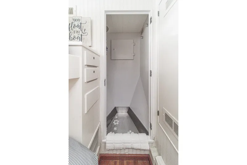 Slide: The Image of Narrow hallway inside a 1969 Burger Flush Deck yacht, featuring white cabinetry and decor. - 66
