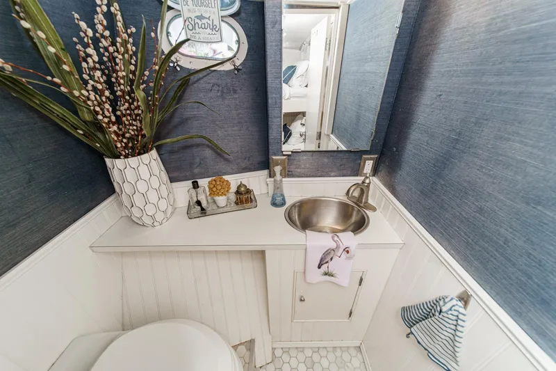 Slide: The Image of Small bathroom on a 1969 Burger Flush Deck yacht with modern decor and stainless steel sink. - 69