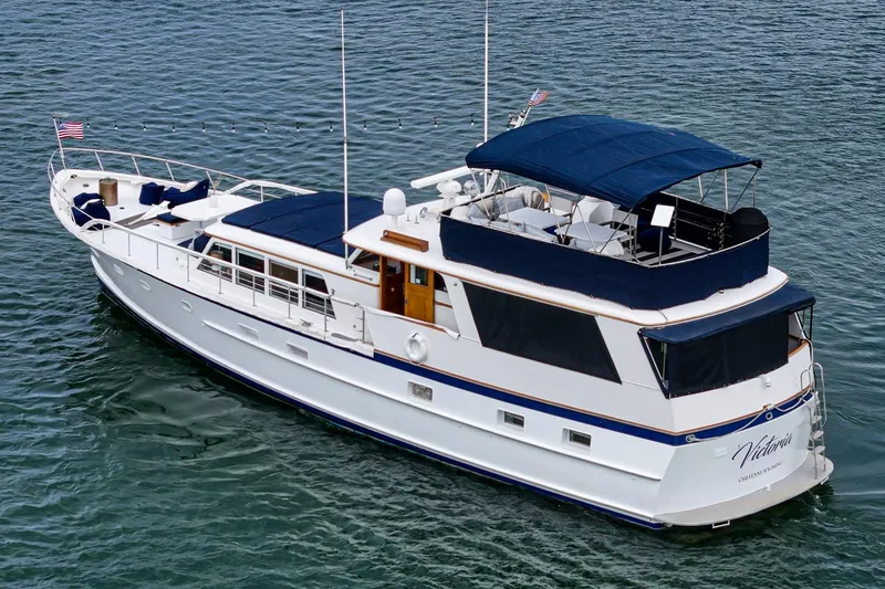 Slide: The Image of 1969 Burger Flush Deck yacht with blue canopy cruising on calm waters. - 7