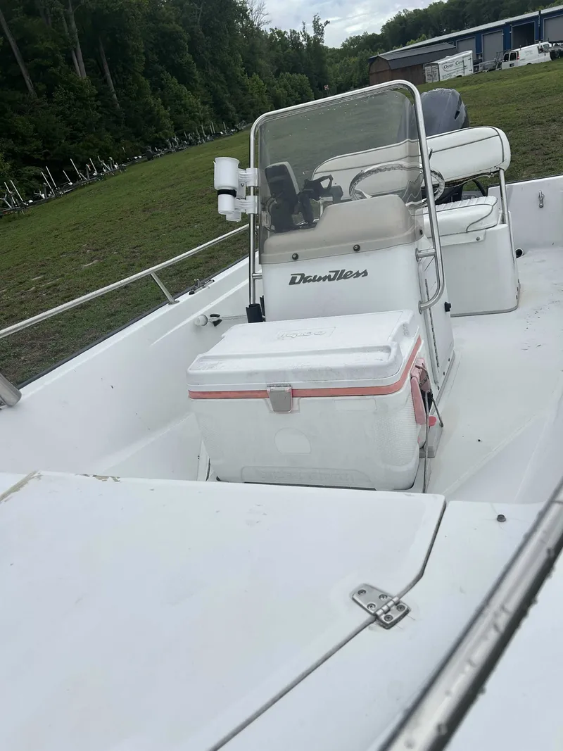 Slide: The Image of A Boston Whaler Dauntless boat is on land with a console and cooler. - 3