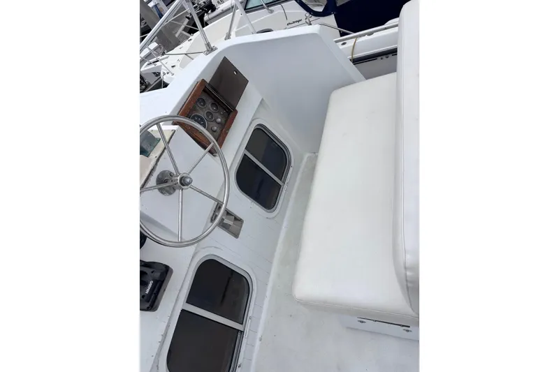 Slide: The Image of 1985 Transpacific Marine Pacific Eagle 32 cockpit with steering wheel and seating area. - 13