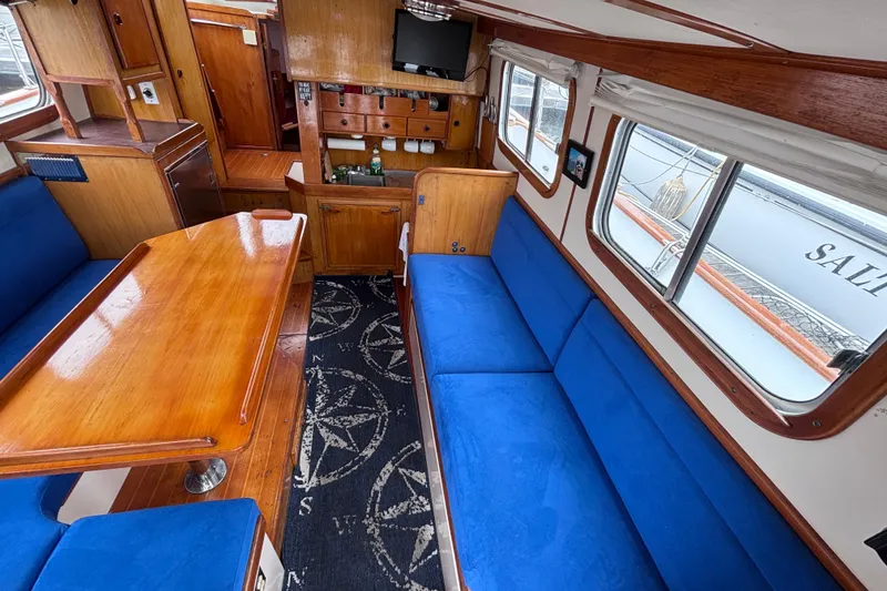 Slide: The Image of Interior of 1985 Transpacific Marine Pacific Eagle 32 with blue seating and wooden table. - 19