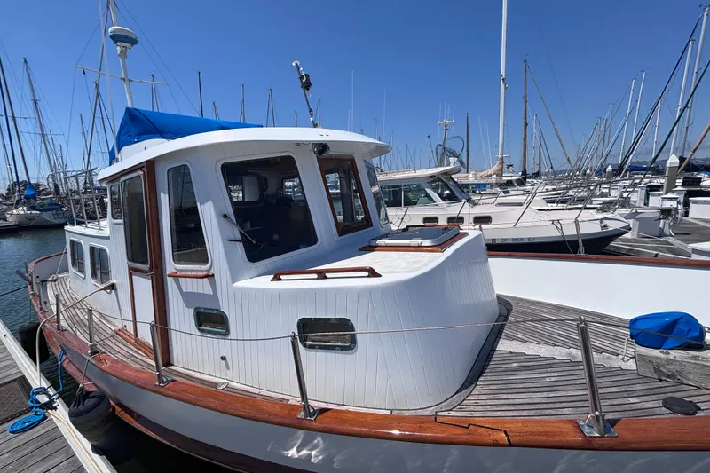 Slide: The Image of 1985 Transpacific Marine Pacific Eagle 32 docked at marina, showcasing classic design and wooden accents. - 2