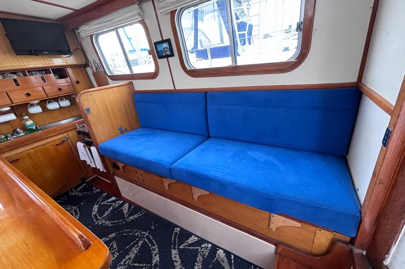 Slide: The Image of Interior of 1985 Transpacific Marine Pacific Eagle 32 with blue seating and wooden cabinetry. - 21