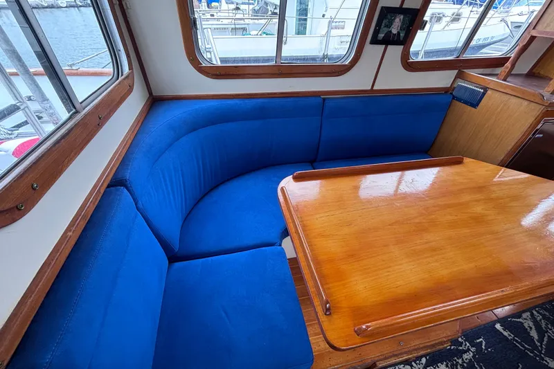 Slide: The Image of Cozy interior of 1985 Transpacific Marine Pacific Eagle 32 with blue seating and wooden table. - 22