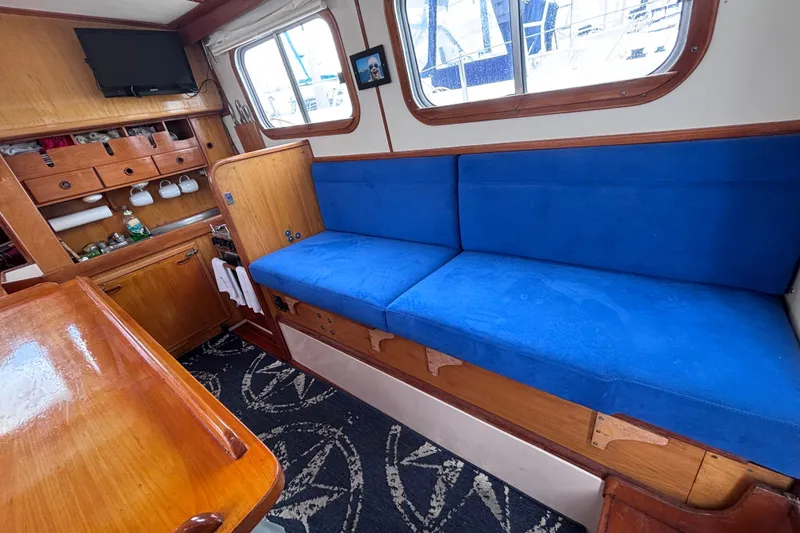 Slide: The Image of Interior of 1985 Transpacific Marine Pacific Eagle 32 with blue seating and wooden cabinetry. - 23
