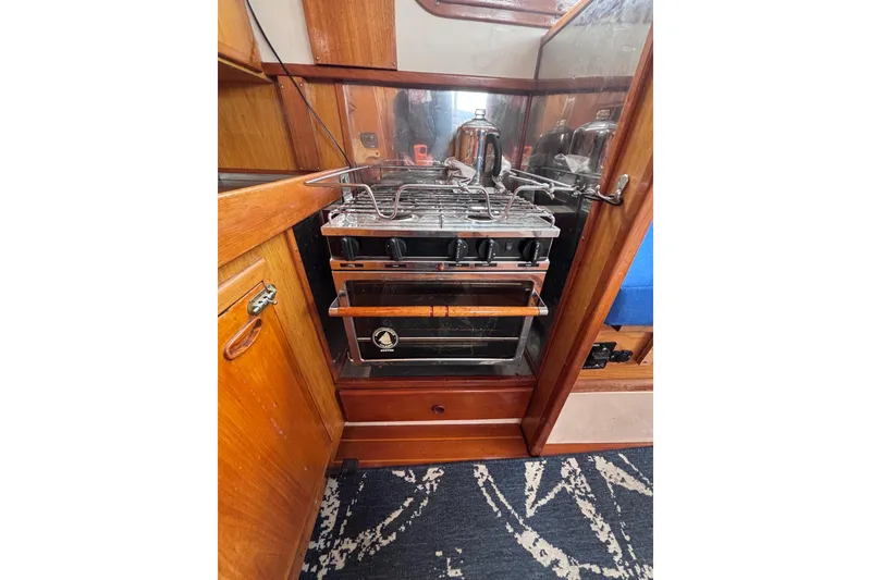 Slide: The Image of 1985 Transpacific Marine Pacific Eagle 32 yacht kitchen with stove and wooden cabinetry. - 38