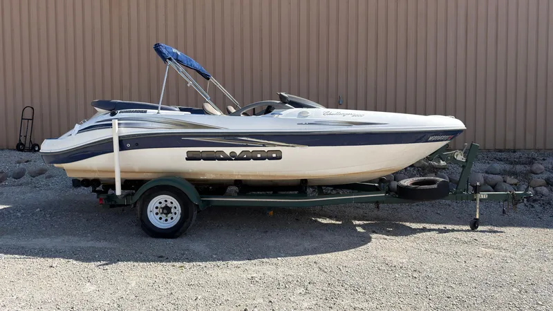 The Image of A white 2002 Sea-Doo Challenger 2000 boat on a trailer, featuring a blue sunshade. - 0