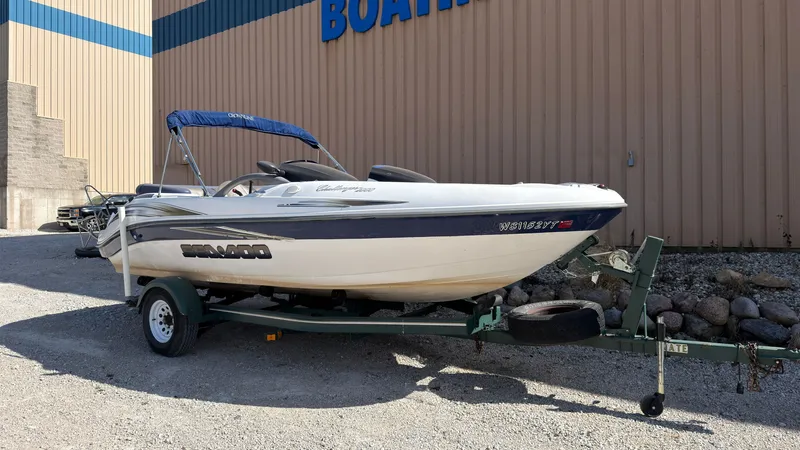 Slide: The Image of A white 2002 Sea-Doo Challenger 2000 boat on a trailer in front of a building. - 1