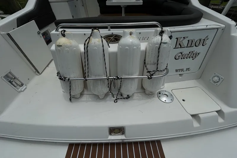 Slide: The Image of Rear view of a 2000 Monterey 330 Sport Yacht with fenders and "Knot Guilty" name. - 4
