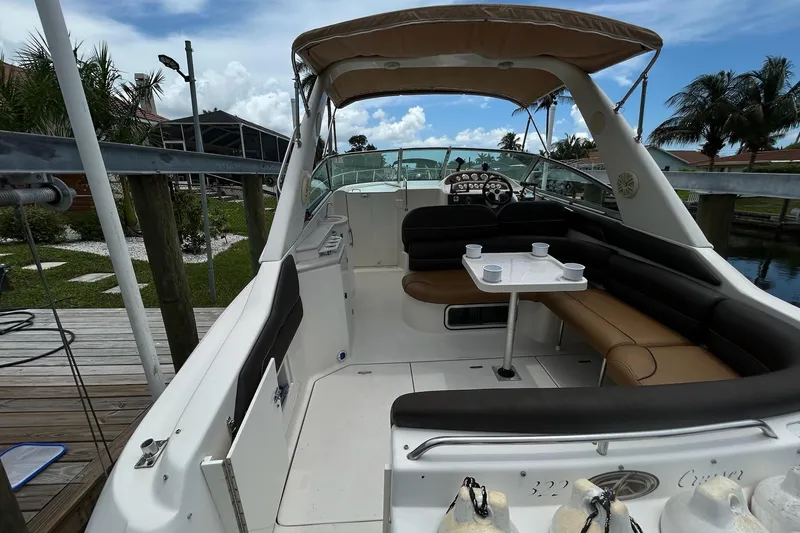 Slide: The Image of 2000 Monterey 330 Sport Yacht interior with seating and table, docked near palm trees. - 5