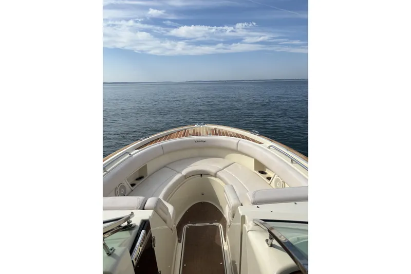 Slide: The Image of 2017 Chris-Craft Calypso 26 boat with elegant seating, cruising on calm waters under a clear sky. - 8
