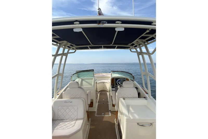 Slide: The Image of 2017 Chris-Craft Calypso 26 boat interior with seating, helm, and ocean view. - 11