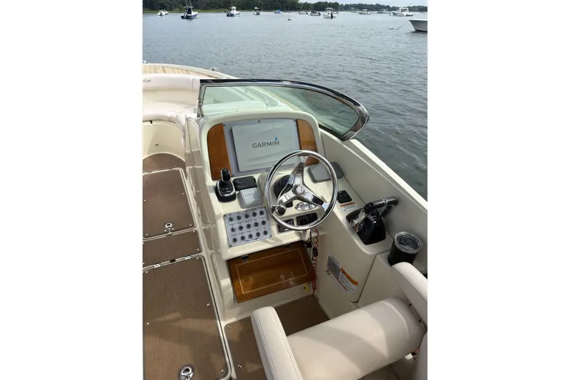 Slide: The Image of 2017 Chris-Craft Calypso 26 boat helm with Garmin navigation system on calm water. - 12